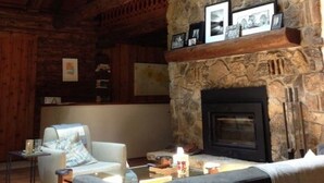 A cozy room with a stone fireplace, wooden beams, and a sofa. - Cozy Cabin in The Driftless (Cross Plains)