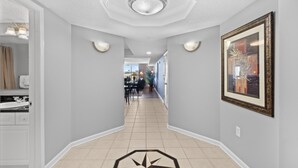 A hallway with a tiled floor, a ceiling light fixture, and a framed picture on the wall. - Yacht Club Villas #3-502 Wonderful Waterway Views! (North Myrtle Beach)