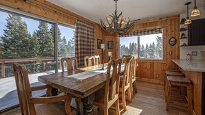 A wooden interior with a large dining table, chairs, and a chandelier. - Goetzl by Hauserman Rental Group (Tahoma)