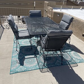 Enjoy a meal or a moment of relaxation on this rooftop patio with a table and chairs.