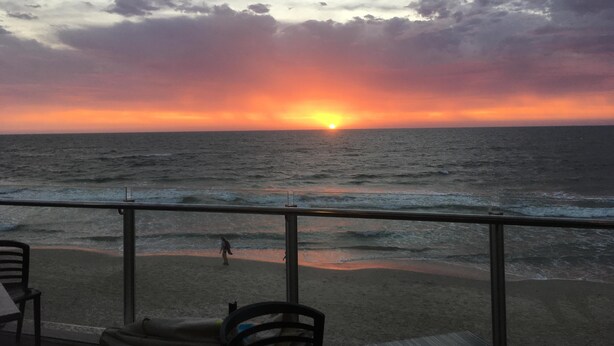 A sunset view from a balcony overlooking the ocean with a beach in the foreground. - Adelaide Style Accommodation - Getaway-Close to City In elite North Adelaide (North Adelaide)