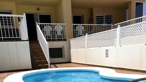 A swimming pool with a white deck and a covered area with lounge chairs. - Villa with private pool, terraces and direct access to the sea +Wifi (Corralejo)