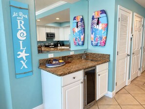 A kitchen with a granite countertop, white cabinets, and a built-in microwave. - Modern Beachfront Condo w/ Corner Views & Pool | Sleeps 10 (Gulf Shores)