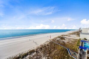 Une vue sur la plage, avec un ciel dégagé, une plage de sable et un espace piscine.