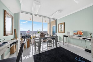 Um espaço de escritório moderno com uma mesa, computador e vista para o oceano.