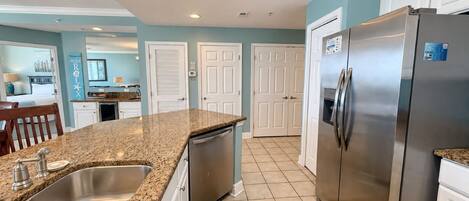 A kitchen with granite countertops, stainless steel appliances, and a tiled backsplash.