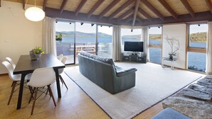 Un amplio salón con una mesa de comedor, sofá y televisor de pantalla plana.