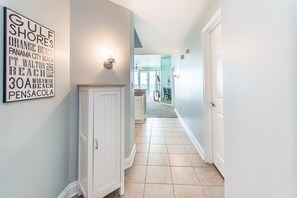 Enter a hallway leading to a dining area with a table and chairs.