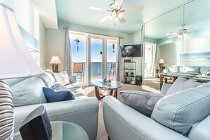 Relax in a serene space with a sofa, armchairs, and ocean views.