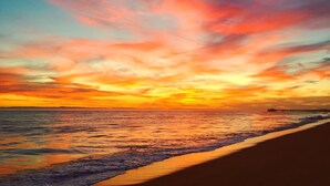 A beach with a pier extending into the water, under a colorful sunset sky. - Breathtaking Views, Steps to the Sand, Beach Resort (Oceanside)
