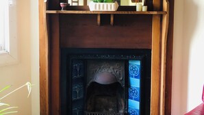 A fireplace with a white shelf above it, a red vase on the mantel, and a wooden mantelpiece. - the whitehouse Port fairy in  the heart of town,  pet friendly (Port Fairy)