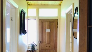 A hallway with wooden flooring, a white rug, and a wooden door with a sign. - the whitehouse Port fairy in  the heart of town,  pet friendly (Port Fairy)