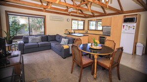 Un espacio de estar moderno con comedor, cocina y un amplio ventanal que ofrece vistas al exterior.