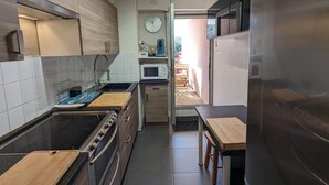 Een moderne keuken met roestvrijstalen apparatuur, een houten aanrecht en uitzicht naar buiten.