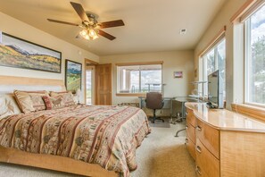 Une chambre à coucher avec un grand lit, un bureau, une chaise et une coiffeuse.