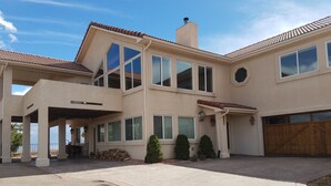 Una casa de dos pisos con un porche cubierto, ventanas amplias y un garaje.