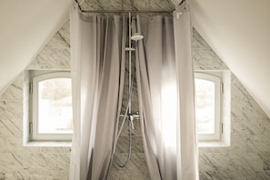 Bathtub, hair dryer, towels, toilet paper