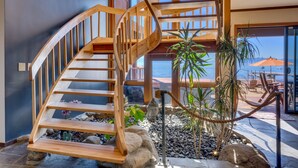 A wooden spiral staircase leading to a balcony with a view of the ocean. - Lake Front Retreat With Your Private Beach & Hot Tub  (Tahoe Vista)