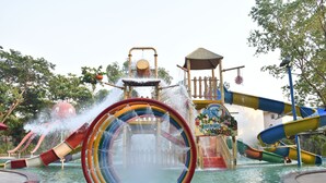A water park with a central water slide, multiple slides, and a jungle-themed play area. - Sai River Resort (Khalapur)
