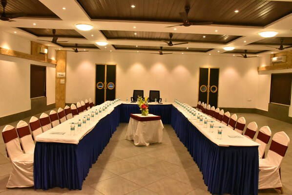 A conference room with a long table, chairs, and ceiling fans.