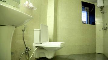 Un baño con inodoro, lavamanos y ducha.