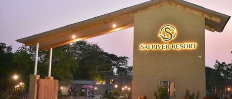 La entrada al Sai River Resort, con un corredor cubierto y un cartel que muestra el nombre del complejo.
