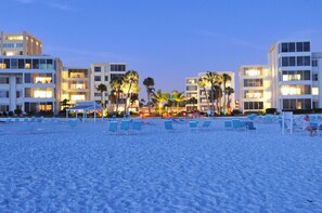 A beach with rows of sun loungers and a hotel in the background. - Island House Beach Resort 9S (Siesta Key)