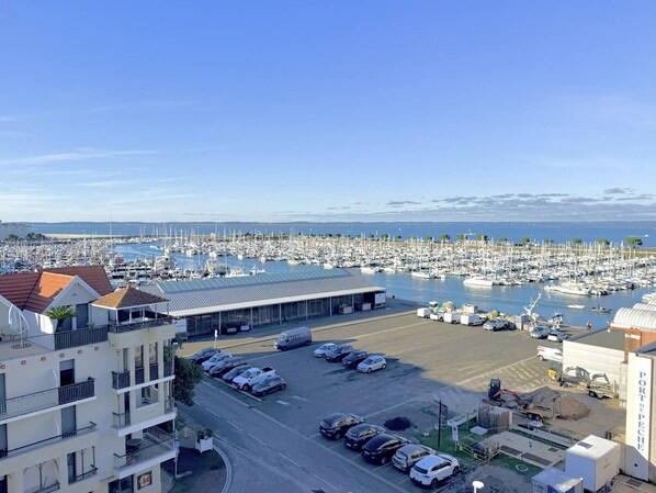 A marina with numerous boats docked, a parking area with cars, and a building with a sign reading "PORT DE PECHE". - Studio with Balcony, Pool and Parking - Arcachon Aiguillon (Arcachon)