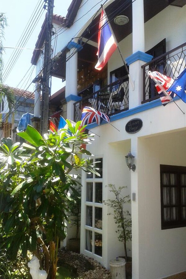 A two-story building with balconies, flags, and a sign that reads "Summer Breeze." - Summer Breeze Inn Hotel (Wichit)