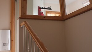 A wooden staircase with a glass door leading to a room. - Cozy inner city apartment: City escape Lüneburg (Lüneburg)