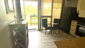 A compact kitchen with a dining area, a small table, and a refrigerator.