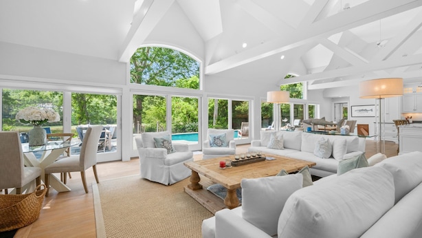 A spacious living room with large windows, a pool view, and a modern interior design. - Bay Breeze Escape—Pool, Game Room & Views (Centerville)
