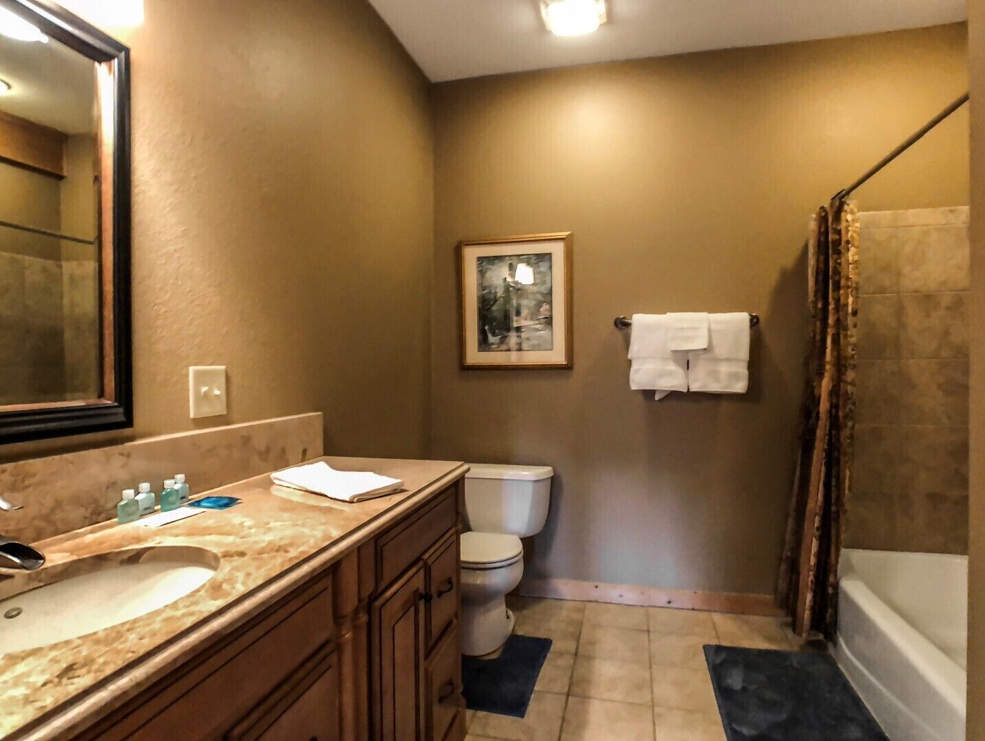 A bathroom with a sink, toilet, and shower.