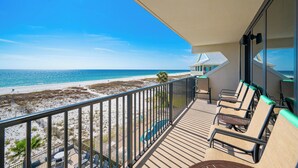 Ein Balkon mit Blick auf Strand und Meer.