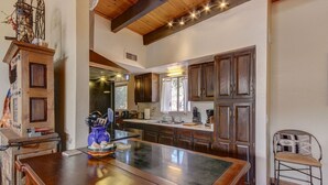 Una cocina amplia con armarios de madera, una isla grande y un techo rústico.
