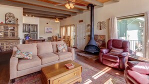 Un salón acogedor con chimenea, sillones de cuero, un sofá y un comedor.