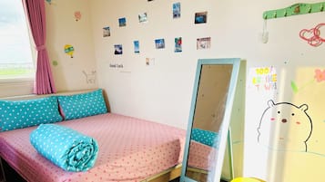 A bedroom with a bed, a mirror, and a wall decorated with photos and drawings.