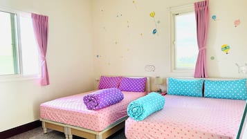 Un dormitorio con dos camas individuales, cada una con una colcha de lunares, cortinas rosadas y una ventana.