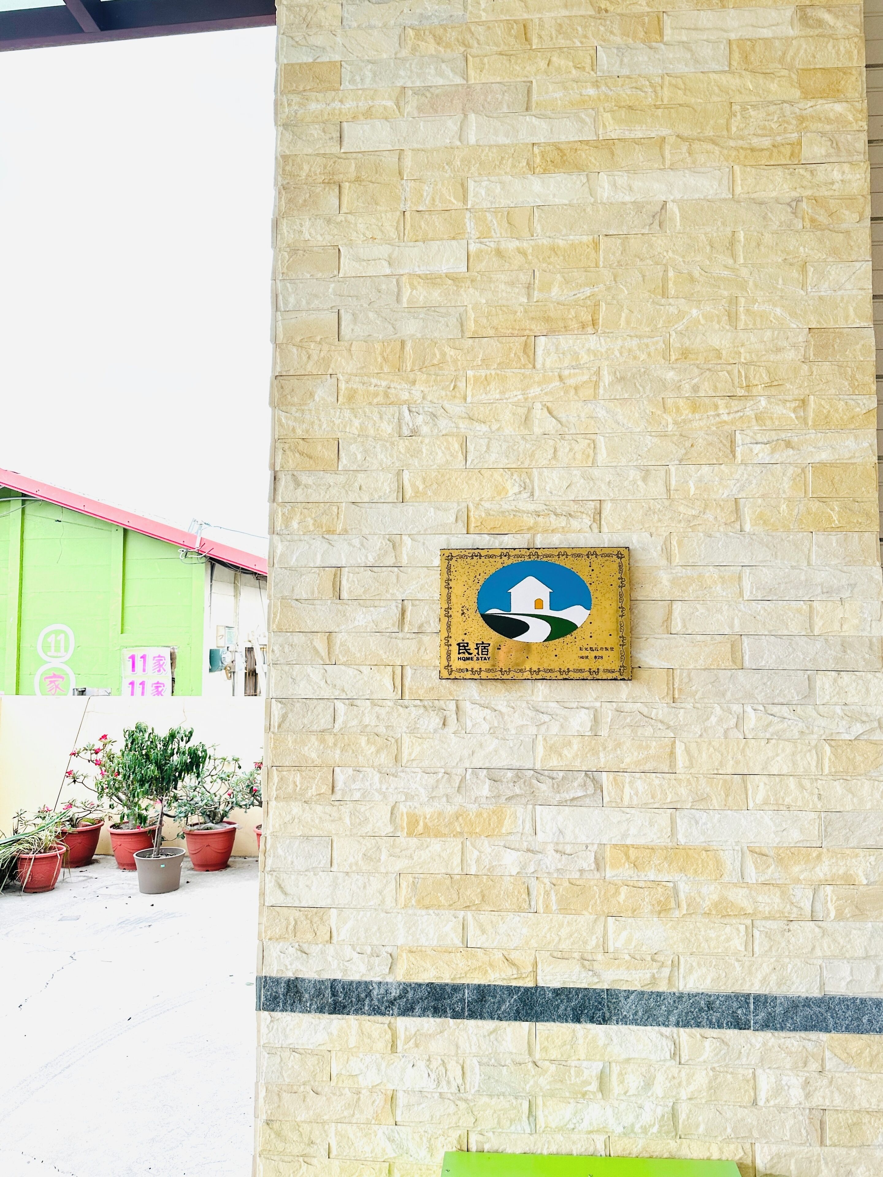 A stone wall with a sign indicating a home stay.