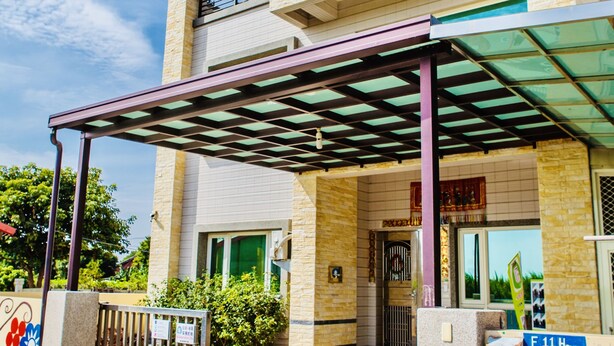 Un bâtiment à deux étages doté d'une entrée couverte, d'un balcon à l'étage supérieur et d'une enseigne indiquant le nom « F11 House ».