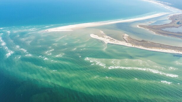 An aerial view of a coastal area with a sandy beach, clear blue waters, and a small peninsula. - Vacation home on the Bodden near Fischland-Darß-Zingst; fenced-in garden. Dogs Welcome (Pruchten)