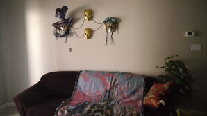 Un salon avec un canapé, une décoration murale et une plante en pot.