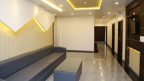Un moderno vestíbulo de hotel con una zona de estar, una recepción y un pasillo que conduce a otras habitaciones.