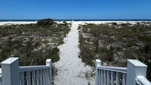 A sandy beach path leading to the ocean, flanked by vegetation and a white fence. - Family Favorite Sea Isles- Indian Rocks Beachfront and Sunsets Galore!! (Indian Rocks Beach)