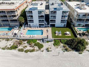 A multi-story residential building with a rooftop pool, outdoor seating, and a beach view. - Family Favorite Sea Isles- Indian Rocks Beachfront and Sunsets Galore!! (Indian Rocks Beach)