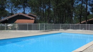 Une piscine rectangulaire entourée d’une terrasse carrelée.