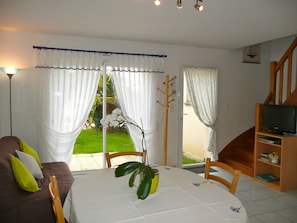 A room with a dining table, chairs, a sofa, a TV, and a staircase. - Your house loan of the sea. Beautiful decoration. (Baden)
