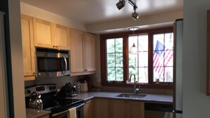 A kitchen with wooden cabinets, a stainless steel refrigerator, a microwave, an oven, and a sink. - Secluded Chatham Cape Cod House Stage Harbor Area (Chatham)