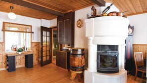 A cozy room with a wooden floor, a white fireplace, and a wooden ceiling. - 2 bedroom beautiful home in Mellerud (Mellerud)