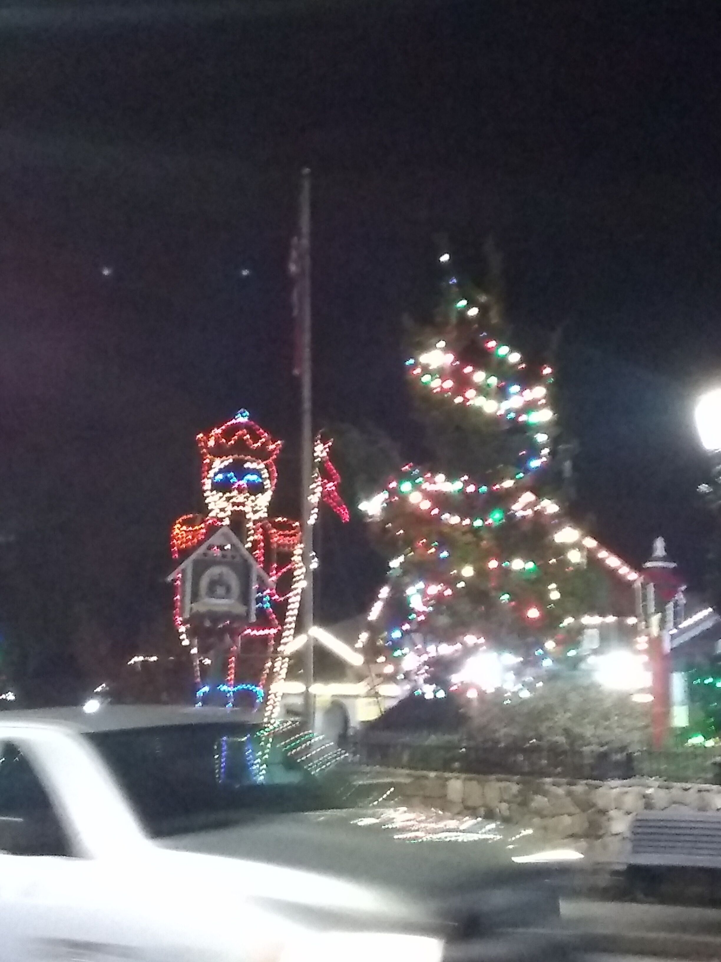 Ein Gebäude mit einer großen, beleuchteten Figur und einem geschmückten Weihnachtsbaum.